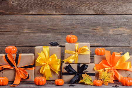 Happy Halloween. Festive composition for Halloween on a wooden background with pumpkins and gifts....