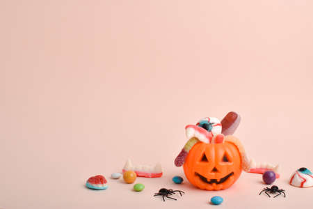 Halloween parties with candy and pumpkin on a beige background, copy spaceの写真素材