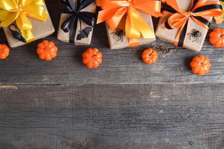 Halloween background with gifts and pumpkins on a wooden background. copy spaceの写真素材