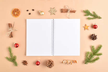 The template is a clean open notepad with a place for text on a beige background with various natural decorations for Christmas. Flat top view, a place to copy. Spicy decorations for the new year.の写真素材