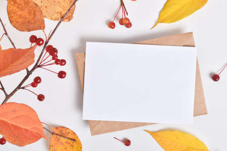Invitation template with an envelope on a beige background with an autumn branch of an apple tree. A romantic note. Flat layout, top view, a place to copy. Flat layout, top view, a place to copy.の写真素材