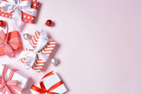 A bunch of red and white gifts on a pink background. Flat lay, top view, copy space.の写真素材
