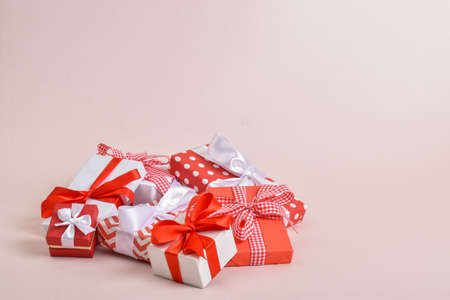 A bunch of red and white gifts on a pink background. Flat lay, top view, copy space. Happy Valentine's Day, Merry Christmas, happy new year.の写真素材