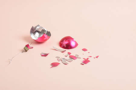 A broken glass Christmas ball on a pink background. A broken Christmas toy.の写真素材