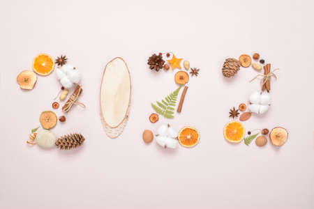 The numbers 2022 are laid out with natural ingredients on a beige background. Themed Christmas card for the holiday. New Year and Christmas. Ecodesign. Minimalism.の写真素材