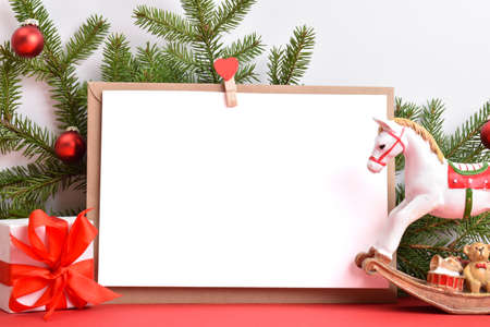 Christmas background from an envelope with gifts and a fir branch and a horse on a red background. Happy New Year 2022.の写真素材
