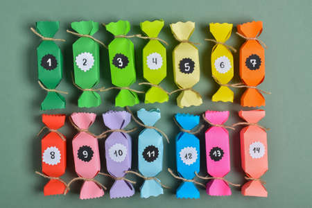 In a row there are colorful paper candy boxes for snacks and sweets. Advent calendar.
