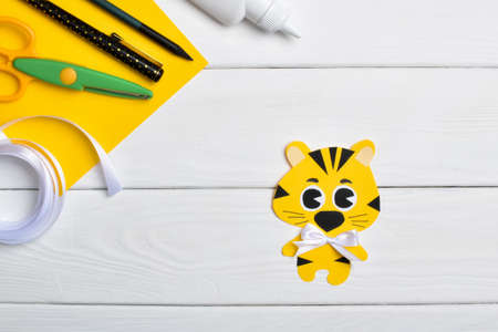 DIY tiger. Step by step. Handmade. Step 6. Glue the satin bow, and the tiger is ready. Flat lay, top view.の写真素材