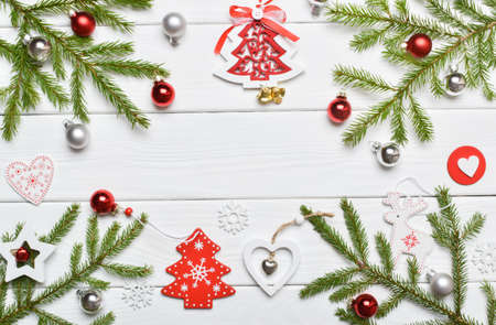 Festive frame background with gift, glass Christmas balls and Christmas wooden toys on a white...
