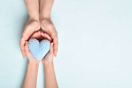 Adults and children's hands hold a blue heart. Healthcare, Love, Organization, Family Insurance and CSR concept, World Heart Day, World Health Day, World Mental Health Day. Copy space. Top view banner.の写真素材