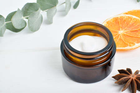 A jar of cream with ingredients on a white background. Skin care, cosmetics. Natural cosmetics....