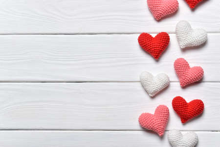 Background with knitted hearts on white. Flat layの写真素材