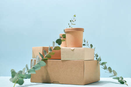 Eco-banner with paper packaging on a neutral blue background. Takeaway food delivery. Environmental...