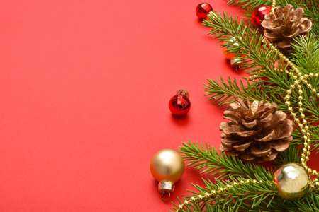 Christmas background with cones and a fir branch on a red background. Happy New Year 2022. Flat layout, top view, place to copy.の写真素材