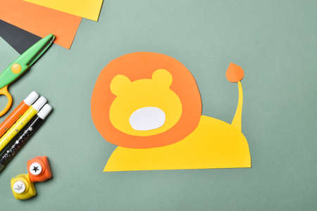 DIY lion. We make a lion out of colored paper. Step-by-step instructions. Step 3: Glue the muzzle and tail. Flat lay, top viewの写真素材
