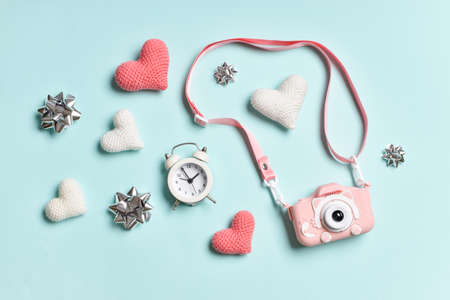 Valentine's day background. Valentine's Day greeting card. A pastel-colored banner with a camera, lollipops, hearts and bows. Space for copying. Various festive accessories in pink and white tones on a blue background. Copy space. Flat lay, top view.の写真素材