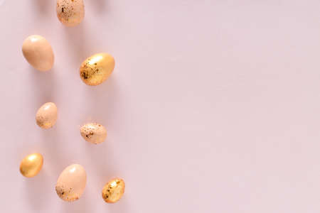 Various Easter eggs of yellow shades lie on a pink background. copyspace. Flat lay, top view.の写真素材