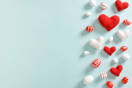 Easter card with red and white eggs and knitted hearts with a copy of the place for the text. Banner for Easter. Festive background. copyspace. Flat lay, top view.の写真素材
