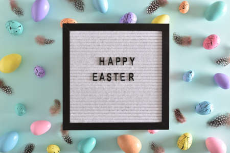 Felt board with the inscription happy Easter with pastel colored eggs and feathers with a copy of the place for the text. Banner for Easter. Festive background.の写真素材