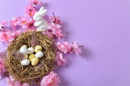 Easter composition with a nest, eggs and flowers. Happy Easter. copyspace. Flat lay, top view.