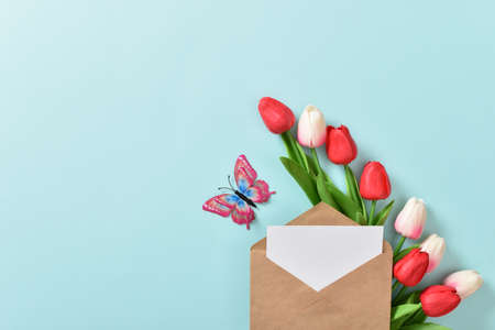 A festive banner with tulips and an envelope on a light blue background. Mother's Day, Women's Day, happy birthday. copyspace. Flat lay, top view.の写真素材