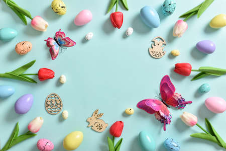 A frame with tulip flowers, painted Easter eggs and butterflies. Decor for the feast of Holy Easter....