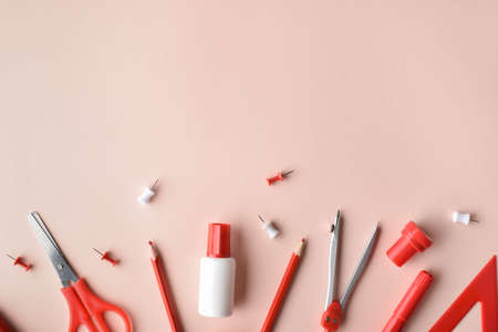 Various office supplies in red on a beige background. back to school. A banner with office elements...
