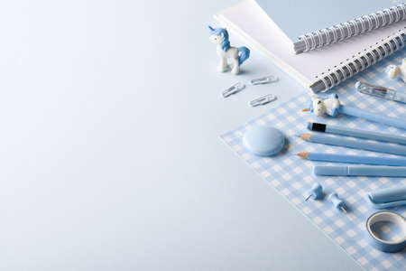 Various blue stationery items lie on the side on a light blue background. back to school. A banner with office elements with space for text. Space for copying. Flat position, top view.の写真素材