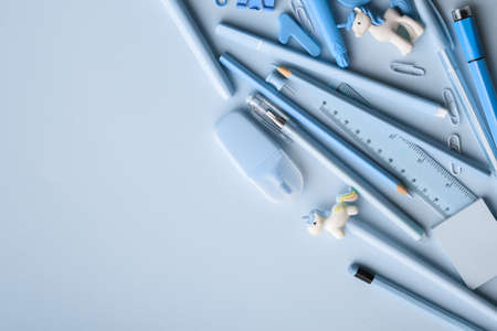 Background with various blue stationery lying in the upper right corner on a light blue background. back to school. A banner with office elements with space for text. copyspace. Flat lay, top view.の写真素材