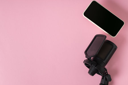 Microphone and smartphone on a pink background with a space for text.の写真素材