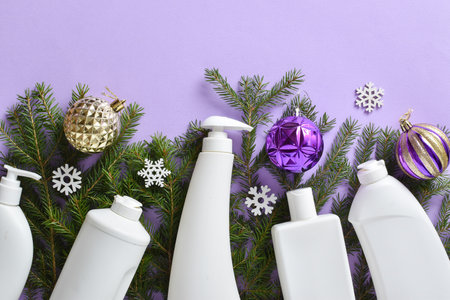 Christmas cleaning. Plastic white bottles with detergent for disinfection of fir branches and Christmas tree toys on a light purple background.の写真素材