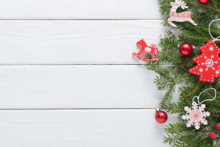Christmas composition, with branches of a Christmas tree and red and white Christmas tree eco-toys on a white wooden background. Happy New Year and Merry Christmas. copyspace. Flat lay, top view.の写真素材