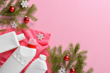 Christmas cleaning. Plastic white bottles with detergent for disinfection of fir branches and Christmas tree toys on a light pink background. copyspace. Flat lay, top view.の写真素材