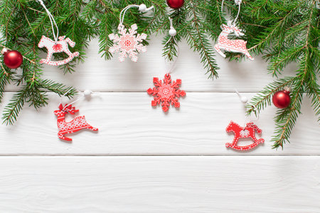Christmas composition with branches of a Christmas tree and red and white Christmas tree eco-toys in the top on a white wooden background. Happy New Year and Merry Christmas. copyspace. Flat lay, top view.の写真素材