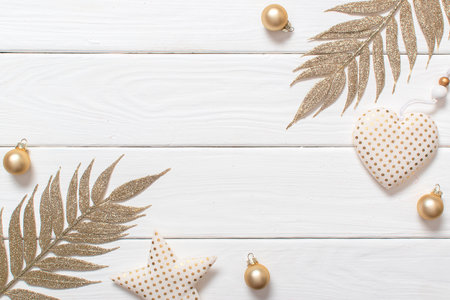 Christmas background. Christmas toys with golden dots on a white wooden background with a place for text. The golden branches and ornaments are made of environmentally friendly material.の写真素材