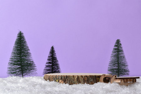 Wooden podium in the snow with festive decor on a light purple background. Christmas decoration with a stage for the presentation of products.の写真素材