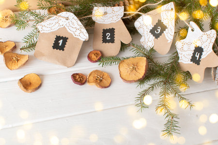 Christmas DIY with your own hands.Advent calendar made of kraft paper using openwork napkins with bokeh. flat lyingの写真素材