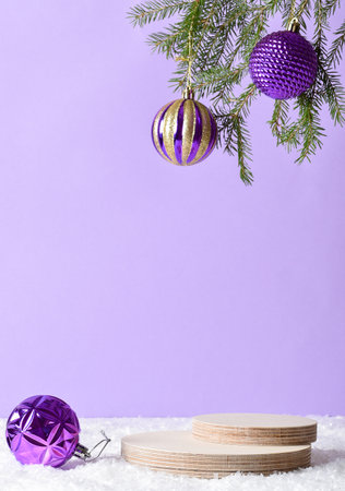 Wooden podium in the snow with festive decor on a light purple background. Christmas decoration with a stage for the presentation of products.の写真素材