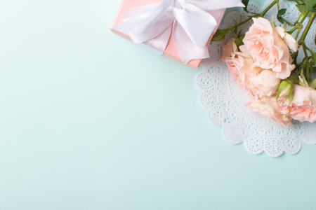 A gift with a bouquet of flowers on a light blue background. Banner for Valentine's Day. Space for copying. Flat position, top view.の写真素材