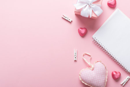 A banner with a notebook, a gift and sweets on a light pink background. valentine's day. Space for copying. Flat position, top view.の写真素材