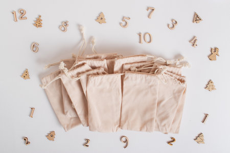 Christmas advent calendar with gift velvet bags and wooden numbers on a white background. Eco-friendlyの写真素材