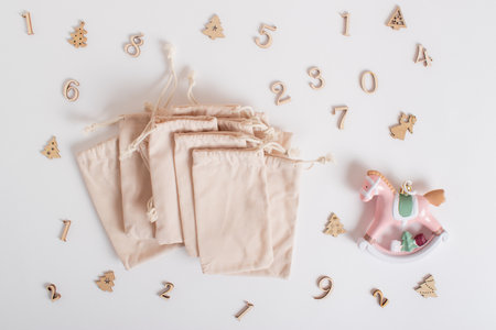 Christmas advent calendar with gift velvet bags and wooden numbers on a white background. Eco-friendlyの写真素材