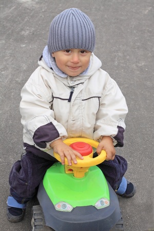 Portrait of the smiling boy driving the toy carの写真素材