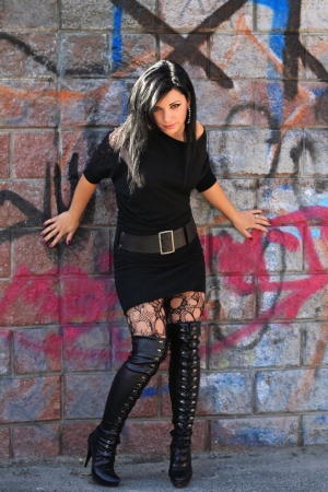 Portrait of the pretty brunette woman standing near wallの写真素材