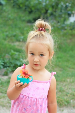 Portrait of the pretty little girl holding a flowerの写真素材