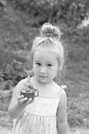 Portrait of the pretty little girl holding a flowerの写真素材