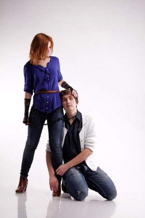 Studio portrait of the young lovely woman holding handsome man on tiesの写真素材