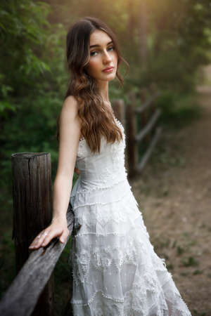 Summer portrait of the girl near the fence.の写真素材
