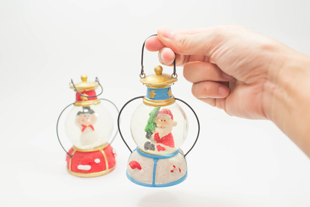 Holding Christmas snow ball or glass globe on white background.の写真素材