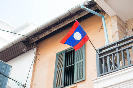 Laos flag hanging outside home is proudly displaying their flag in country.の写真素材